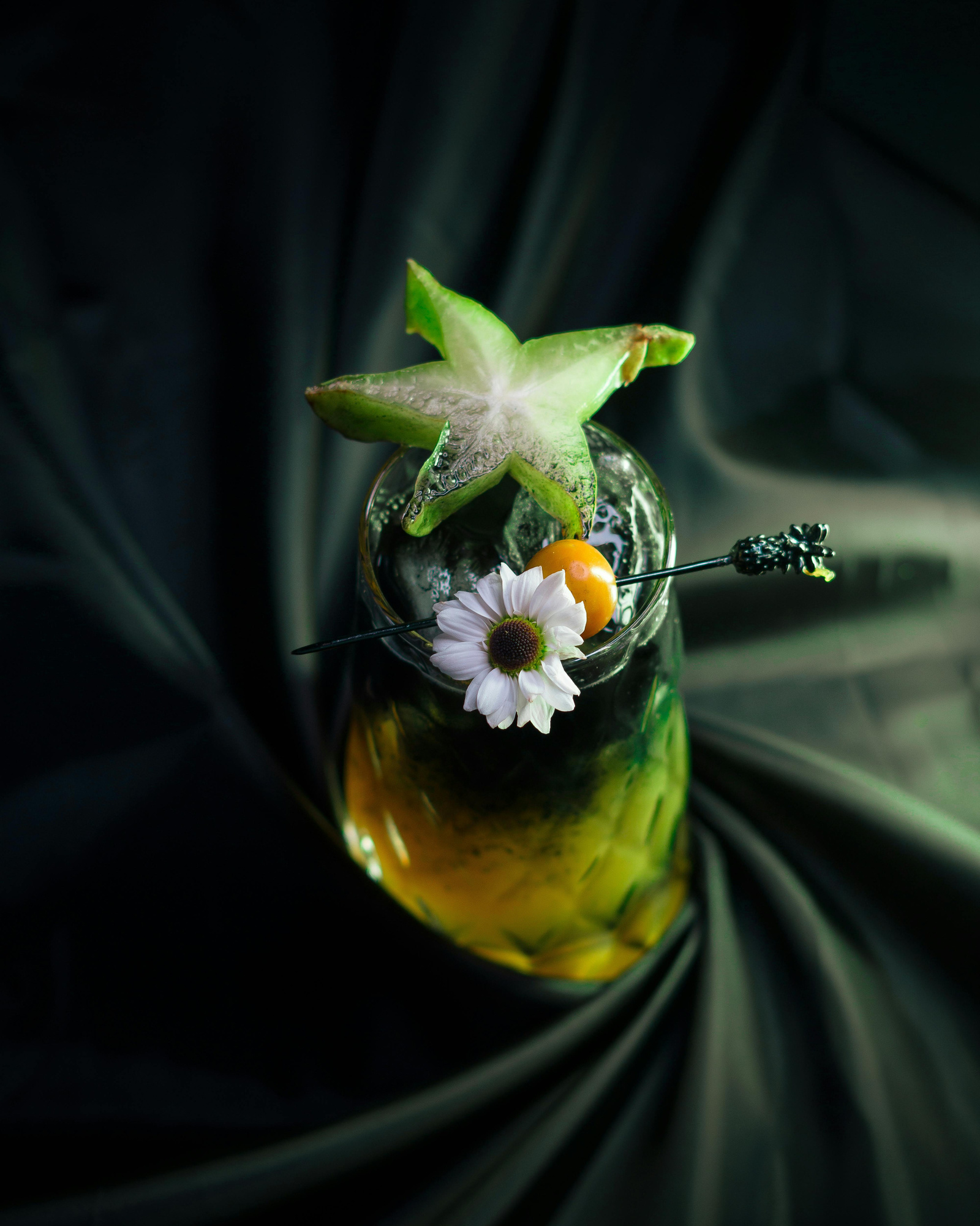 Mocktail in glass vessel with flower garnish